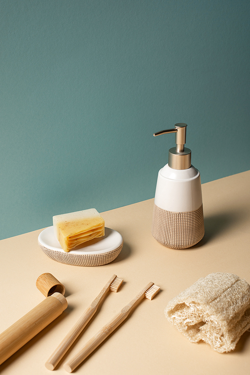 Toothbrushes, toothbrush case with dispenser, sponge and soap dish on beige and grey, zero waste concept
