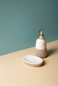 Liquid soap dispenser and soap dish on beige and grey, zero waste concept