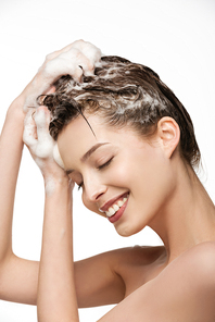 smiling girl washing hair with closed eyes isolated on white