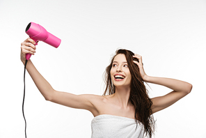 cheerful girl drying long hair with hair dryer isolated on white