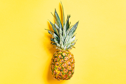 top view of fresh ripe pineapple on yellow background