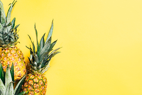 top view of fresh tasty pineapples on yellow background