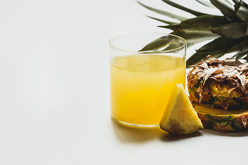 fresh pineapple juice near cut delicious fruit on white background
