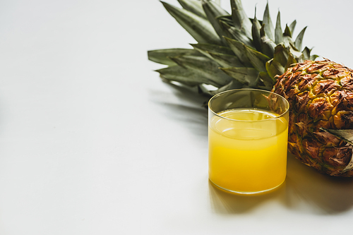fresh pineapple juice near cut delicious fruit on white background