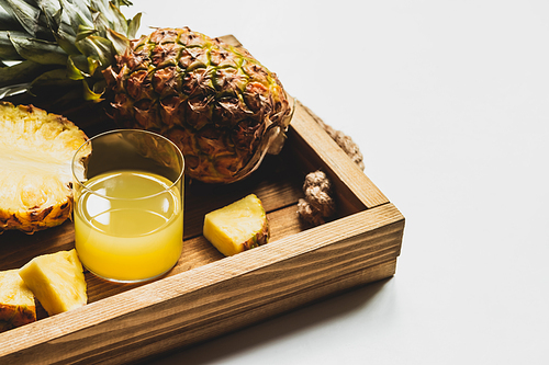 fresh pineapple juice and cut delicious fruit on wooden tray on white background