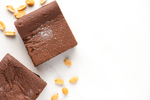 top view of delicious brownie pieces with nuts on white background