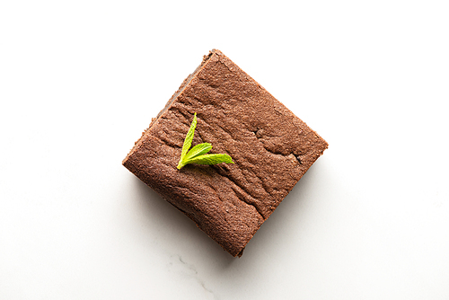 top view of delicious brownie piece with mint on white background