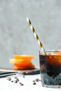 selective focus of cold brew coffee with ice and  straw on white table