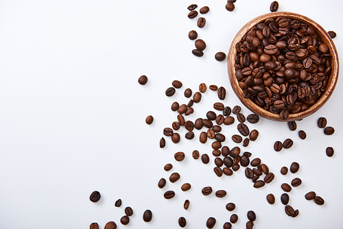 top view of coffee roasted beans in wooden bowl on white background