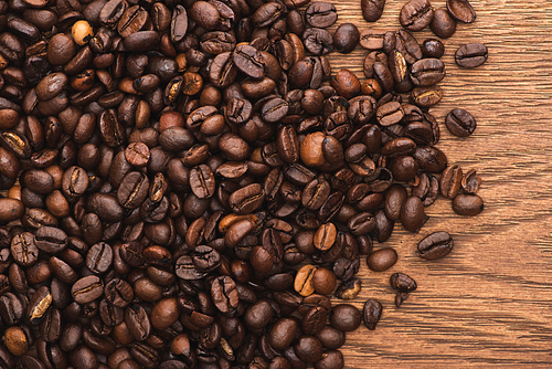 top view of fresh roasted coffee beans on wooden surface