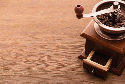 fresh roasted coffee beans in coffee grinder on wooden table