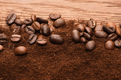 top view of fresh roasted coffee beans and ground coffee on wooden table