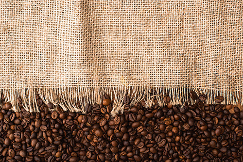 top view of fresh roasted coffee beans and sackcloth