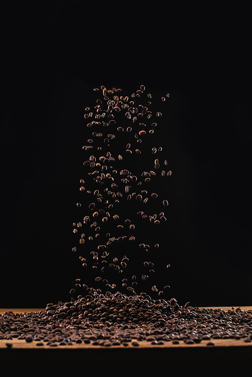 fresh roasted coffee beans in air isolated on black