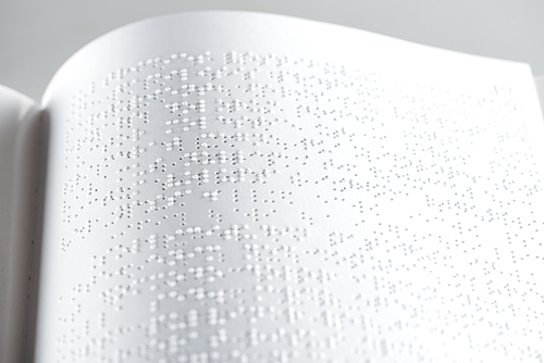 close up view of book with braille text isolated on grey