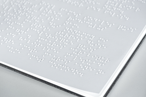 close up view of braille text on white paper isolated on grey