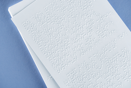 top view of braille text on white paper isolated on violet