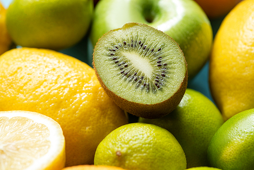 close up view of kiwi half on lemons and limes