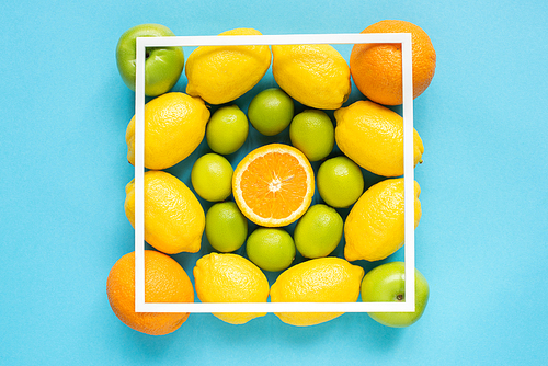 top view of fresh fruits and square frame on blue background