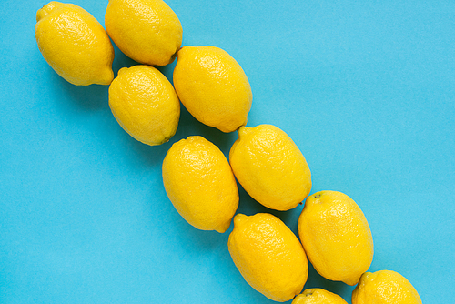 flat lay with ripe yellow lemons on blue background