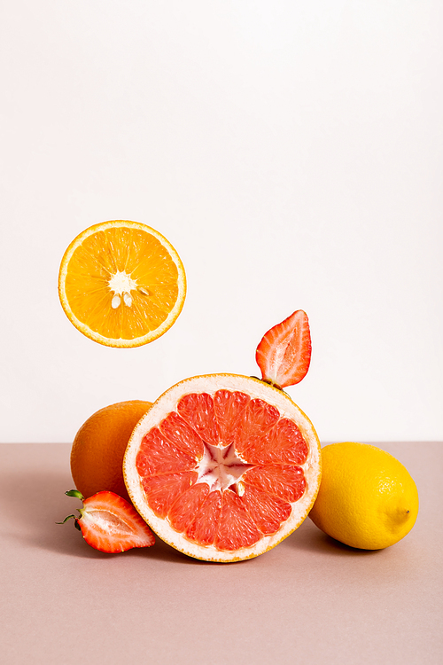fruit composition with citrus fruits and strawberry isolated on beige