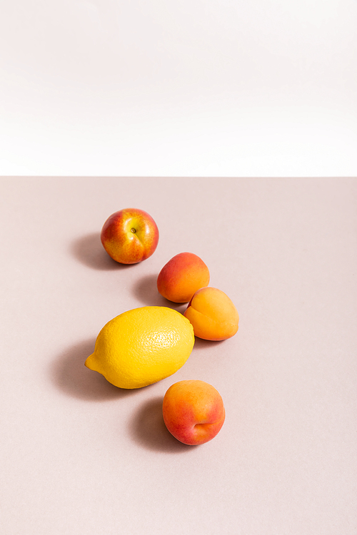 fruit composition with lemon and apricots on beige surface isolated on white