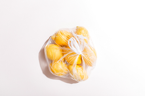 top view of yellow lemons in package on grey table