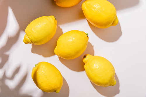 top view of whole yellow lemons on grey table with shadows