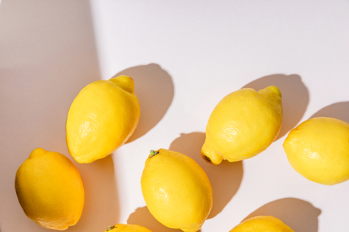 top view of whole yellow lemons on grey table with shadows
