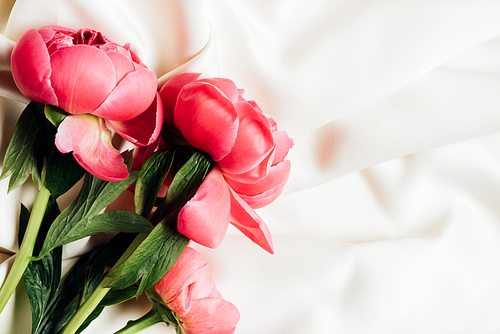 top view of bouquet of pink peonies on white cloth