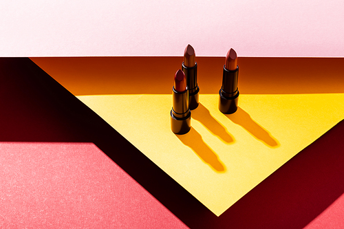 shadows near lipsticks on yellow, pink and crimson