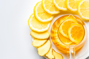 top view of hot tea in glass teapot with lemon slices on white background