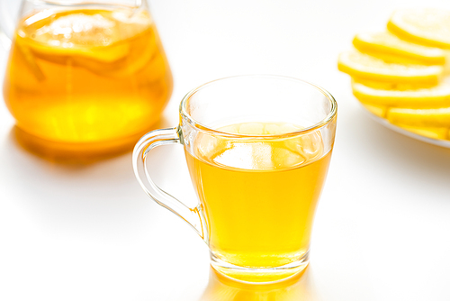 selective focus of hot tea in glass cup on white background