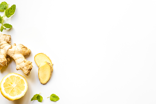top view of ginger root, lemon and mint leaves on white background