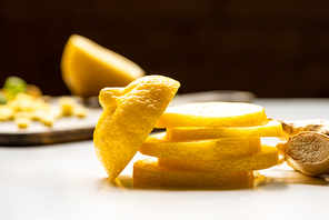 selective focus of sliced lemon and ginger root on white and black background
