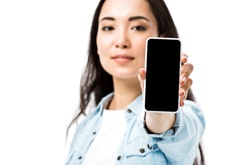 selective focus of attractive asian woman in denim shirt holding smartphone with copy space isolated on white