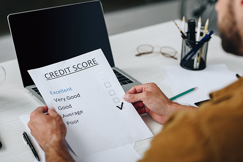 selective focus of young adult man holding credit score