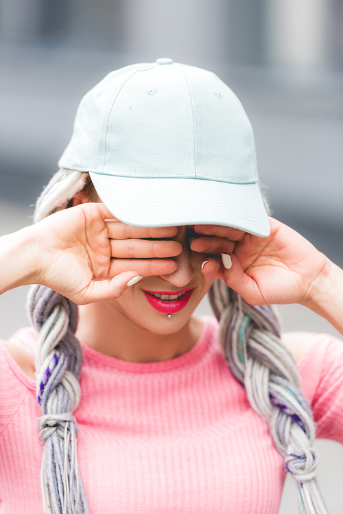 selective focus of stylish girl with dreadlocks in hat Covering Eyes with hands