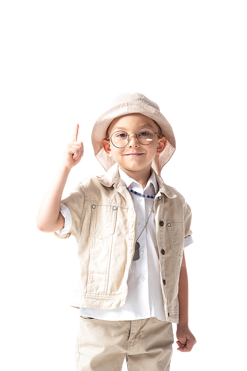 front view of smiling explorer boy in glasses and hat  and showing idea sign isolated on white