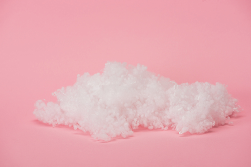 white fluffy cloud made of cotton wool on pink background