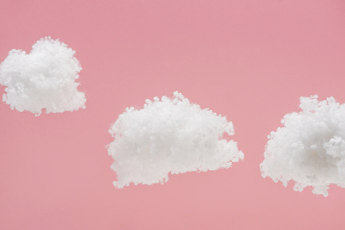white fluffy clouds made of cotton wool isolated on pink