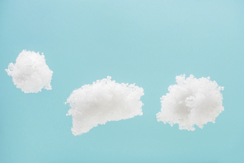 white fluffy clouds made of cotton wool isolated on blue background