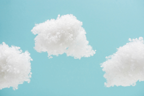white fluffy clouds made of cotton wool isolated on blue background
