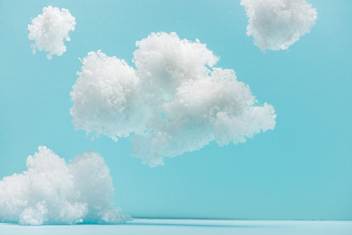 white fluffy clouds made of cotton wool isolated on blue