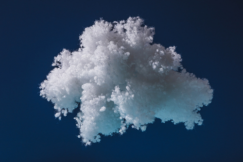 white fluffy cloud made of cotton wool isolated on dark blue