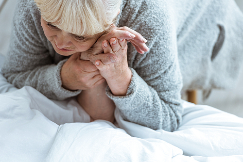 cropped view of unconscious senior man and sad wife in clinic