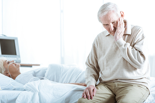 sad senior man and senior woman in coma in hospital