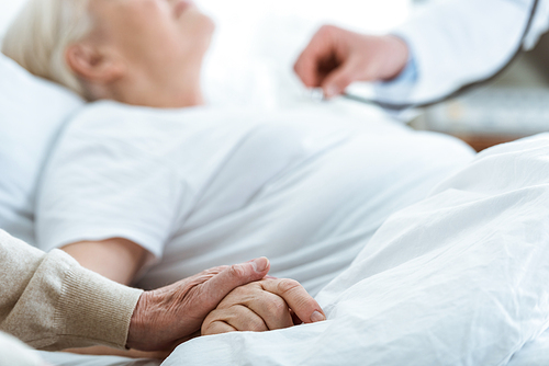 partial view of doctor, sick patient and senior man