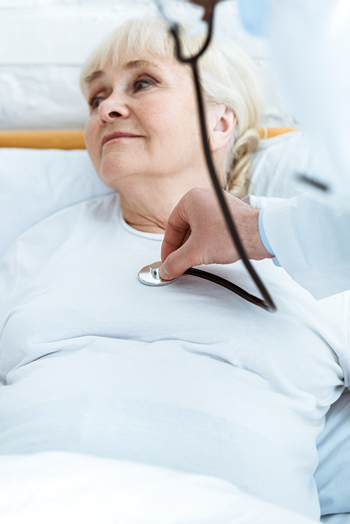 partial view of doctor examining sick patient in hospital