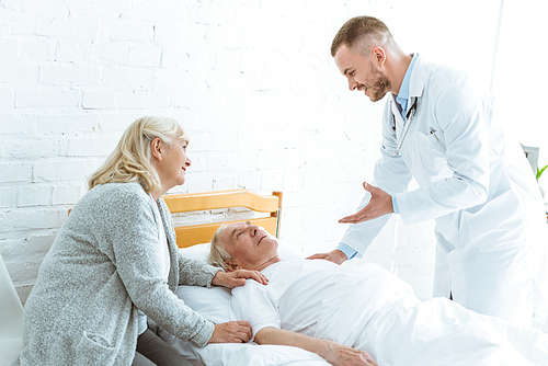 smiling doctor and senior woman near ill patient in clinic